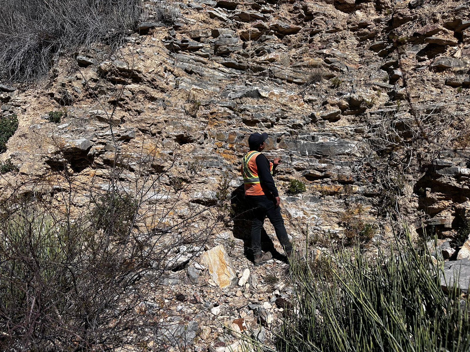 Geólogo de GEOMINXPLOR analizando un afloramiento rocoso en campo